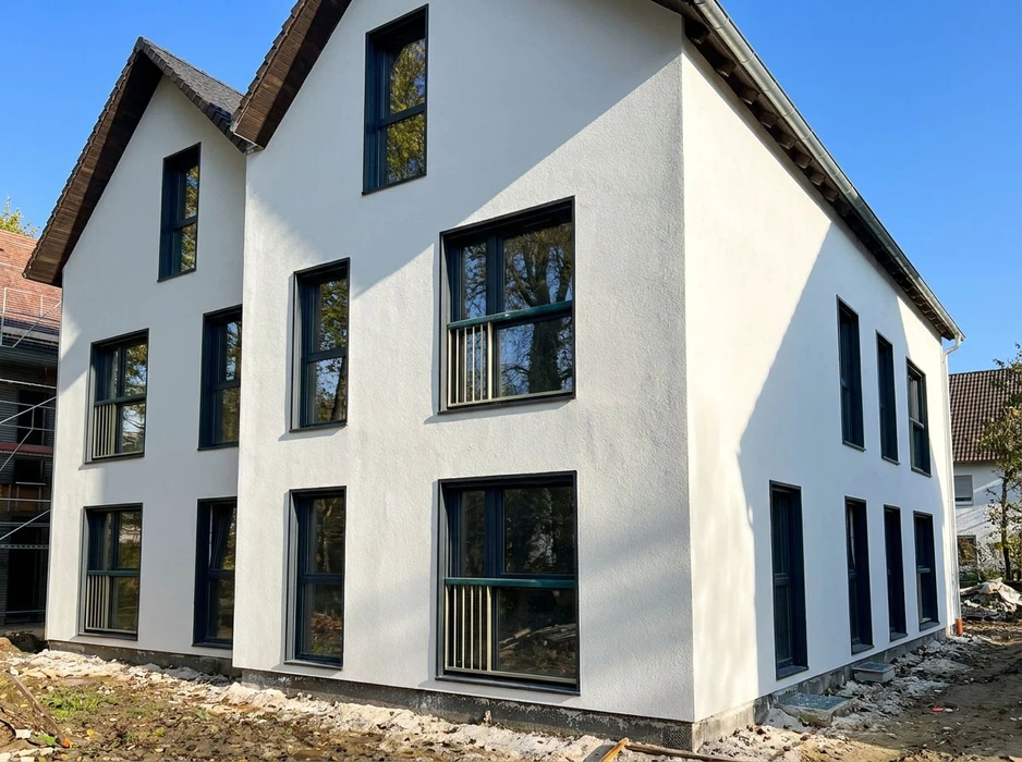 Façade d'immeuble résidentiel moderne avec balcons en verre et garde-corps transparents