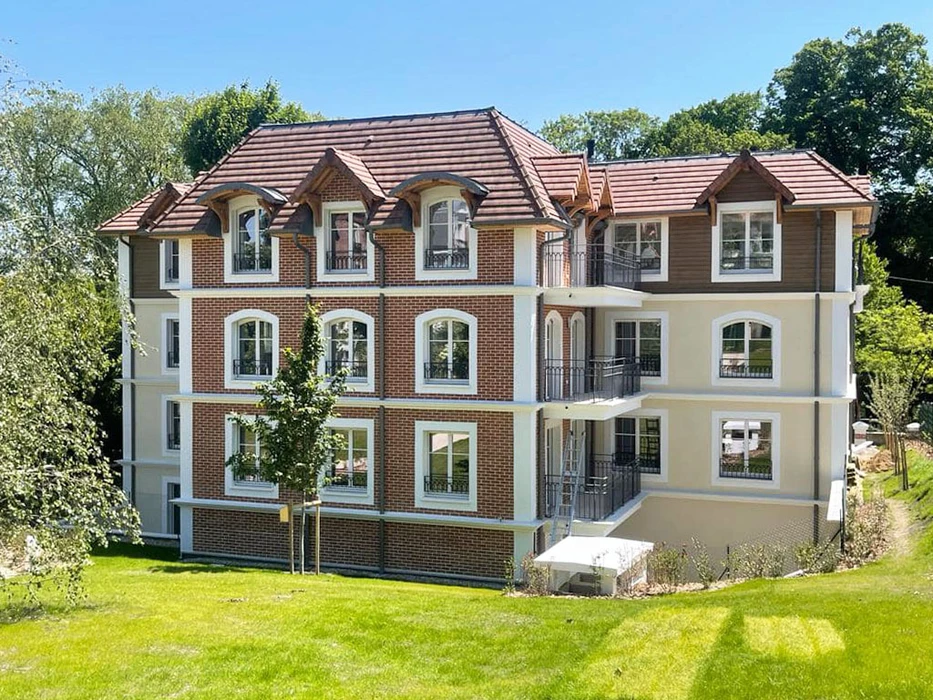 Façade extérieure d'un bâtiment résidentiel avec deux fenêtres équipées de volets roulants en aluminium