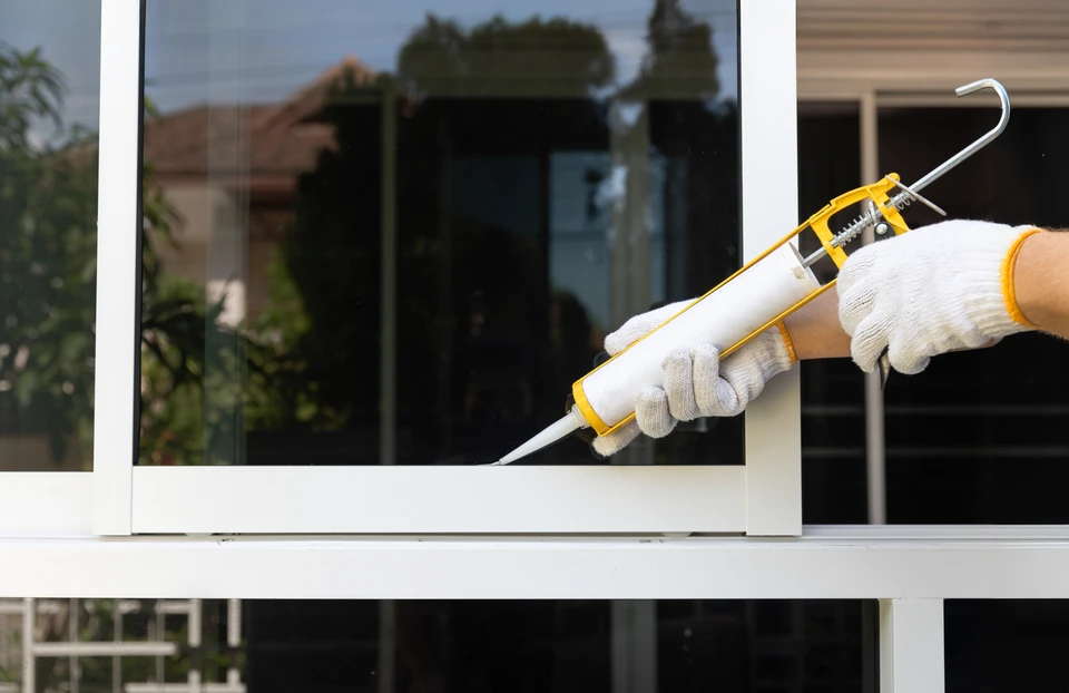 Intérieur résidentiel avec fenêtres PVC blanches ouvertes donnant sur jardin verdoyant