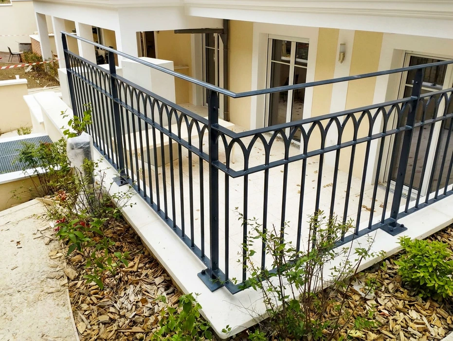Intérieur moderne avec escalier descendant vers niveau inférieur, garde-corps en verre transparent, cuisine ouverte contemporaine au fond avec îlot central sombre