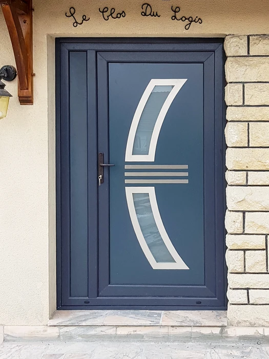 Entrée extérieure d'habitation avec porte en bois peinte anthracite équipée d'un heurtoir décoratif en fer forgé