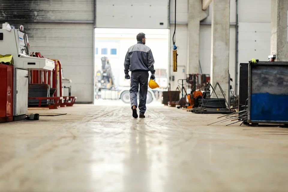 Intérieur industriel avec deux ingénieurs en équipements de protection individuelle analysant des données sur écran d'ordinateur